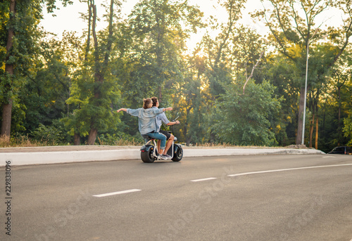 Lovely young couple driving electric bike during summer Modern city life and transportation photo