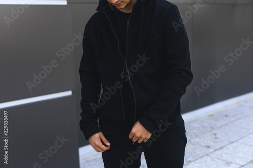 Foto Young man zipping up his hoodie