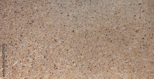 OSB boards are made of brown wood chips sanded into a wooden background. Top view of OSB wood veneer background, tight, seamless surfaces
