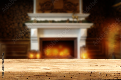 A wooden old table on the background of the fireplace in a Christmas decoration   © magdal3na