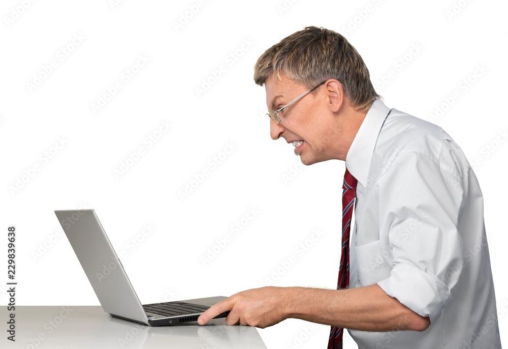 Frustrated businessman using a laptop Frustrated businessman using a laptop
