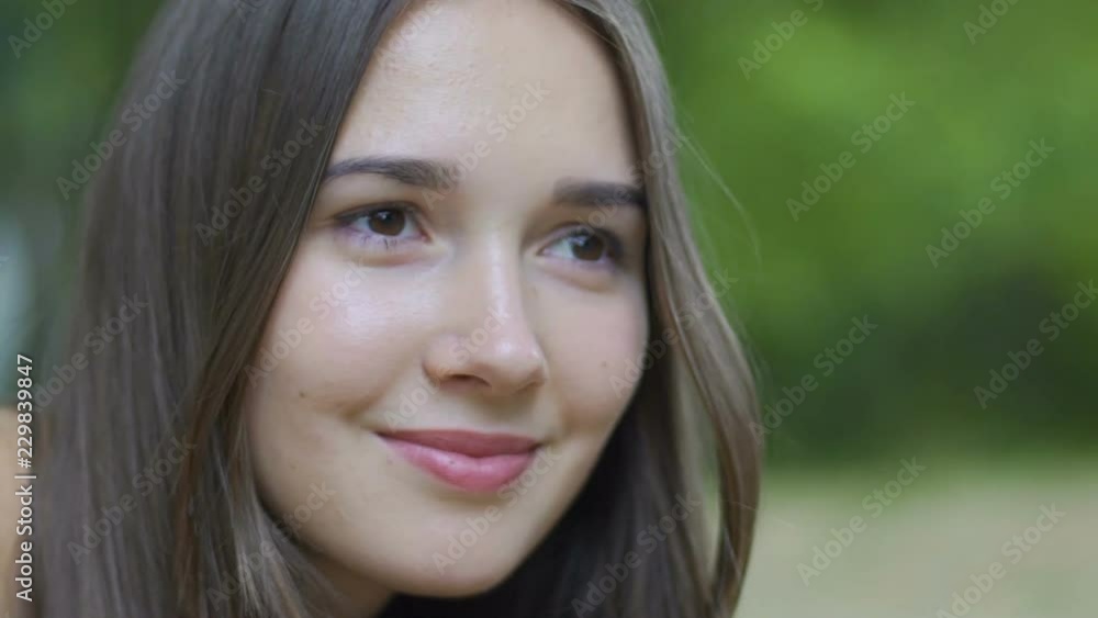 Smiling young woman portrait, beautiful girl soft smile outdoors, female dreams Smiling young woman portrait, beautiful girl soft smile outdoors, female dreams