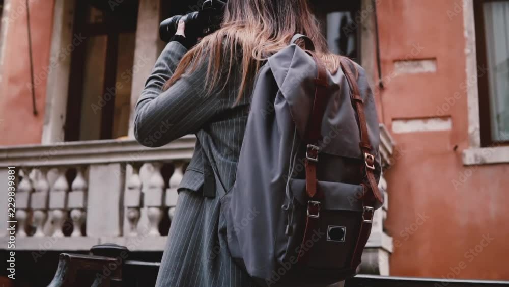 Camera follows beautiful smiling tourist woman taking photo with professional camera in old Venice street slow motion. Camera follows beautiful smiling tourist woman taking photo with professional camera in old Venice street slow motion.