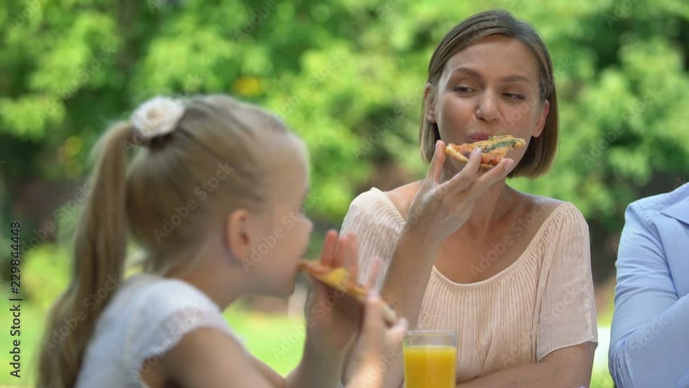 Mother and daughter eating tasty home-made pizza, familys culinary tradition Mother and daughter eating tasty home-made pizza, familys culinary tradition