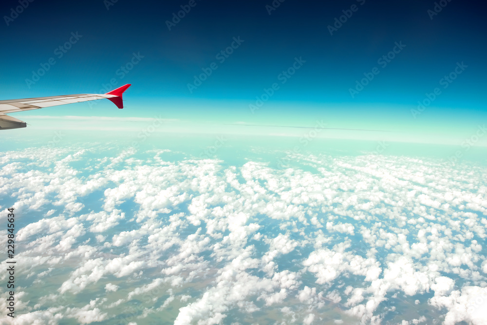 Fototapeta premium Cloud blue sky view aircraft wing airplane window.