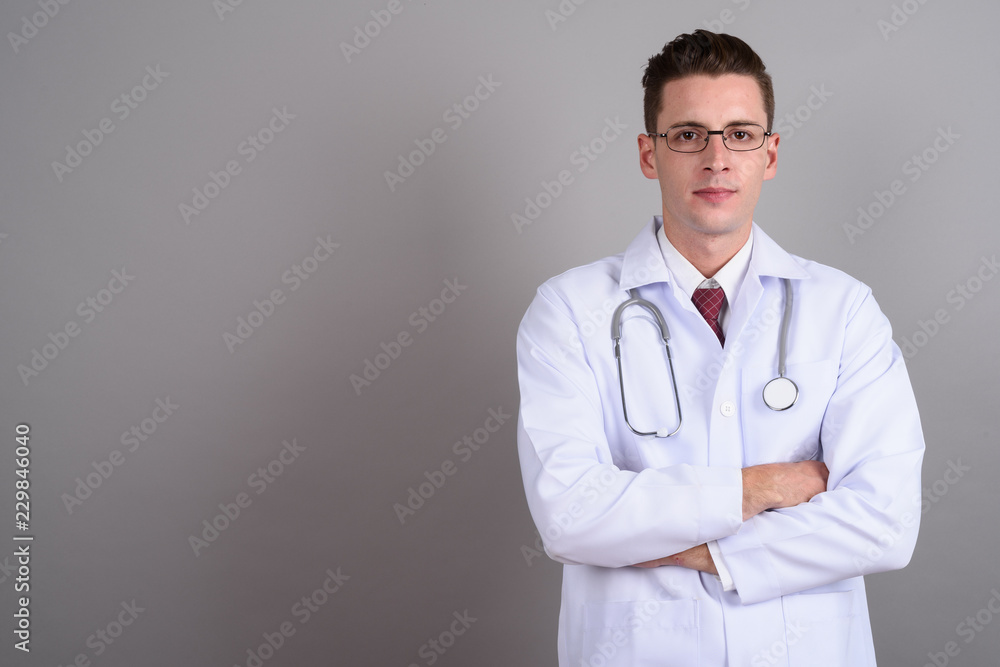 Young handsome man doctor with arms crossed Young handsome man doctor with arms crossed