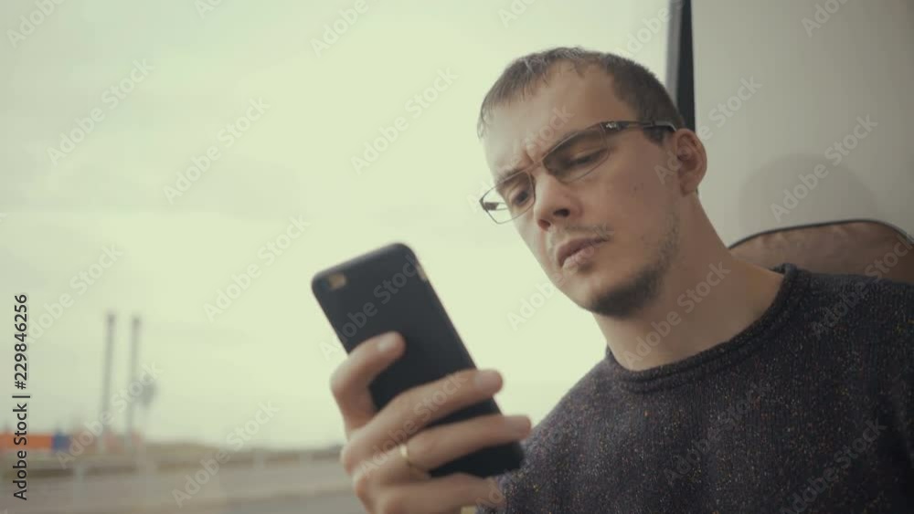 young man using smartphone during bus ride young man using smartphone during bus ride