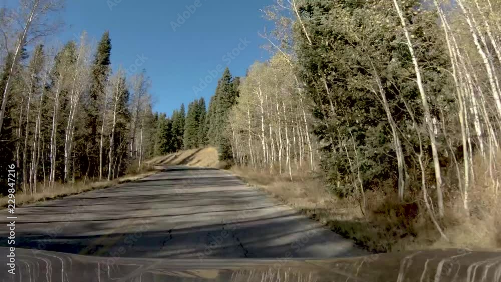 Hyperlapse drive down a mountain road in autumn with a speed ramp slowing and then speeding up to show the snowcapped mountain Hyperlapse drive down a mountain road in autumn with a speed ramp slowing and then speeding up to show the snowcapped mountain