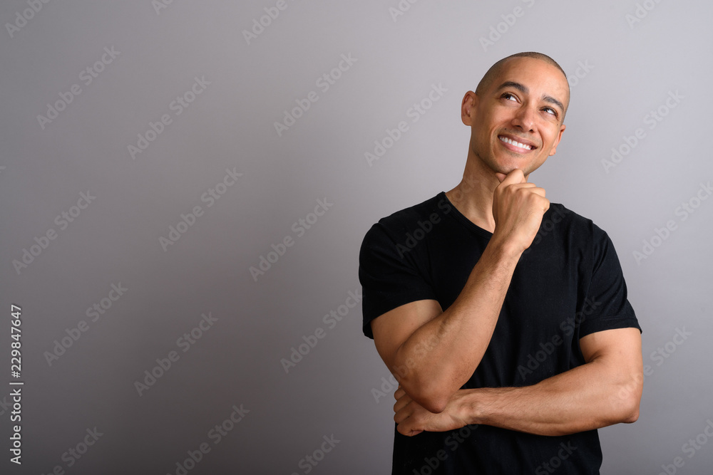 Handsome bald man smiling while thinking and looking up Handsome bald man smiling while thinking and looking up