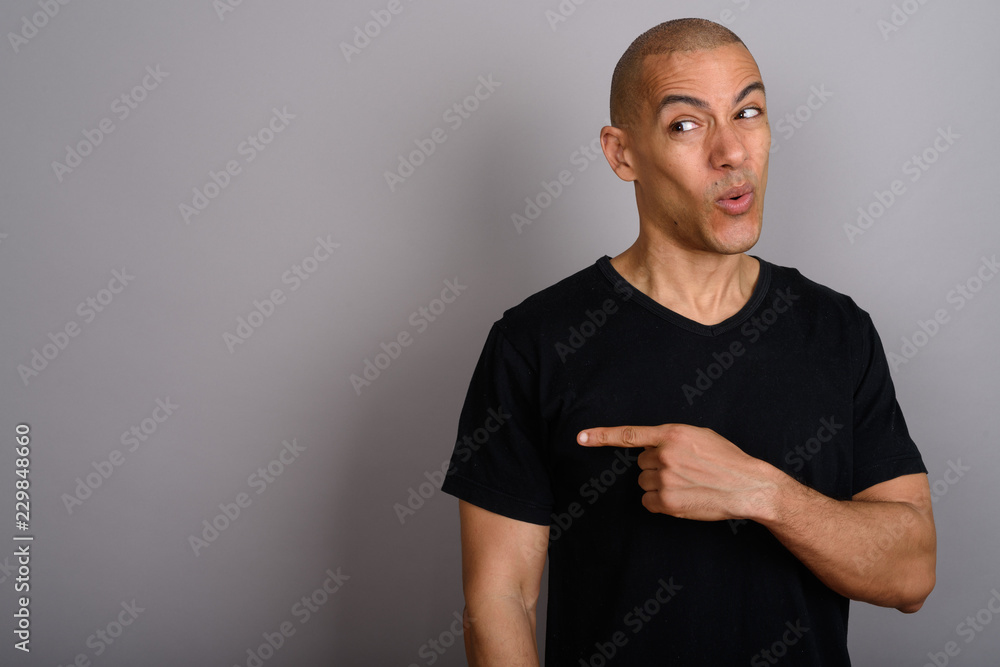 Handsome bald man looking disgusted and pointing finger