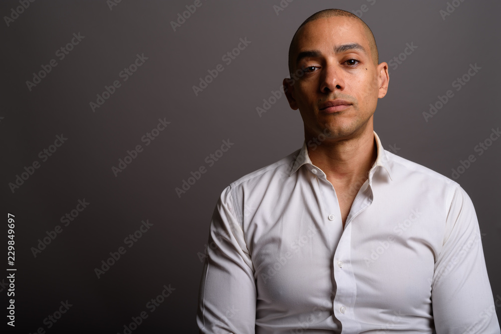 Portrait of handsome bald businessman against gray background Portrait of handsome bald businessman against gray background