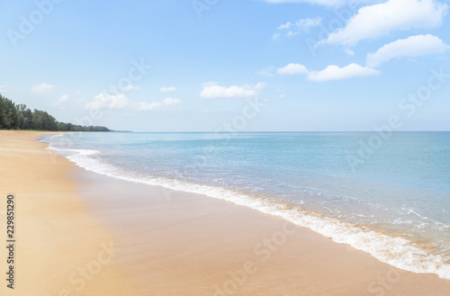 Close up white soft wave rolling splash on empty tropical sandy beach in sunny day © Soonthorn