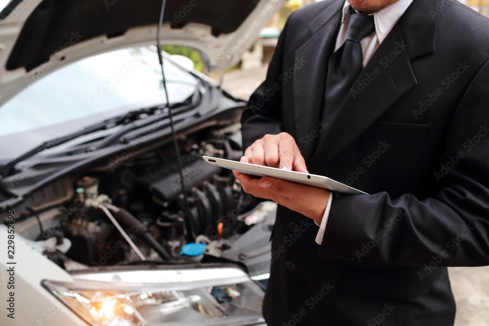 Insurance agent using tablet for insurance claim with broken car Insurance agent using tablet for insurance claim with broken car