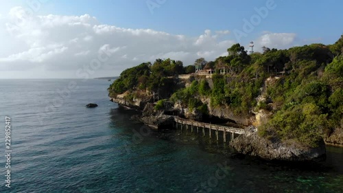 Aerial Pan video of Steep Cliff Shoreline with beautiful sea, coral, mangrove forest and clouds landscape photo