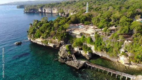 Aerial Birdeye view video of Steep Cliff Shoreline with beautiful sea, coral, mangrove forest and clouds landscape photo