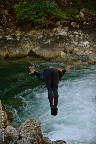 Man jumping in wild river photo