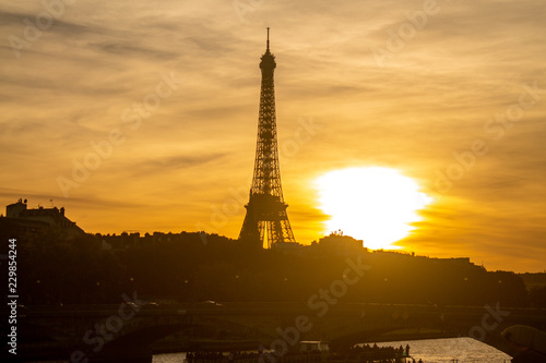Eiffel Tower and the amazing sunset seen from the bridge Alexandre III in Paris, france. A show of colors happening on the sky above the city of love.