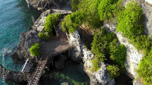 Aerial Backwards video of Steep Cliff Shoreline with beautiful sea, coral, mangrove forest & sky landscape photo