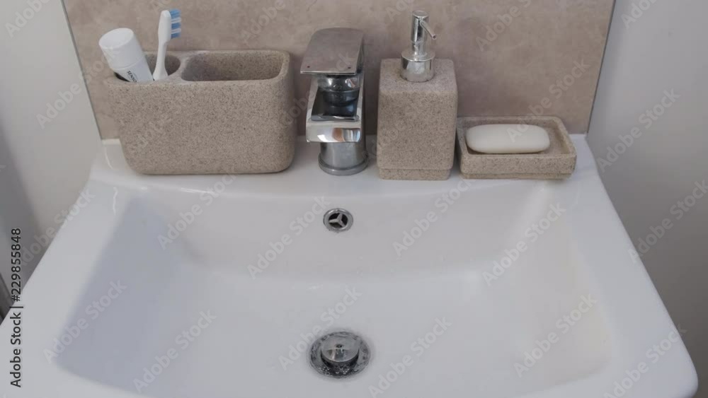 Water running from faucet into a sink Water running from faucet into a sink