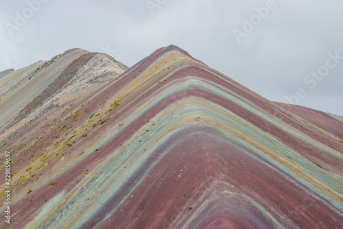 Vinicunca, also called Montaña de Siete Colores, Montaña de Colores or Rainbow Mountain, in a cloudy day, in Perù. © ludovica