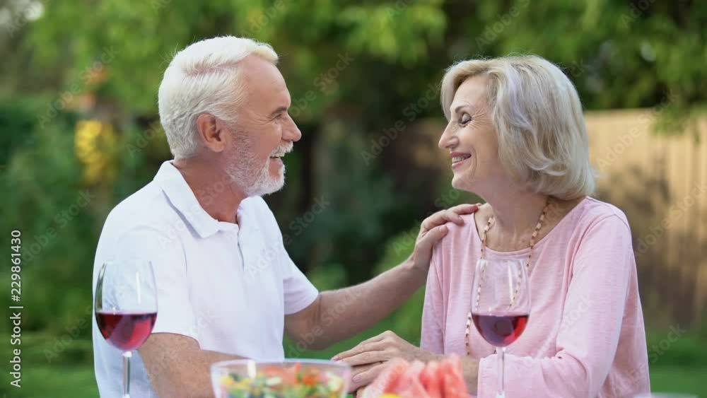 Seniors sitting at table and remembering their life together, happy marriage Seniors sitting at table and remembering their life together, happy marriage