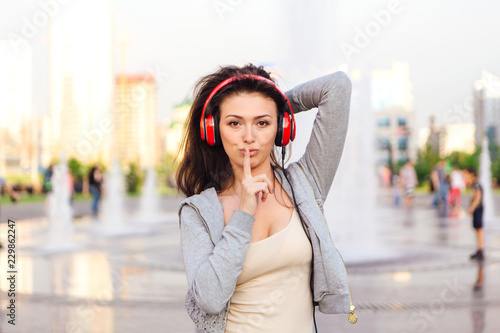 Girl listening to music streaming with headphones. Woman naking shhh sight © Smile
