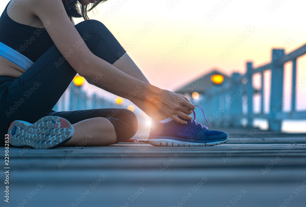 woman sitting on the wooden pier lace tie of the shoe, excercise running and jogging in daily morning healthy lady morning light - obrazy, fototapety, plakaty 