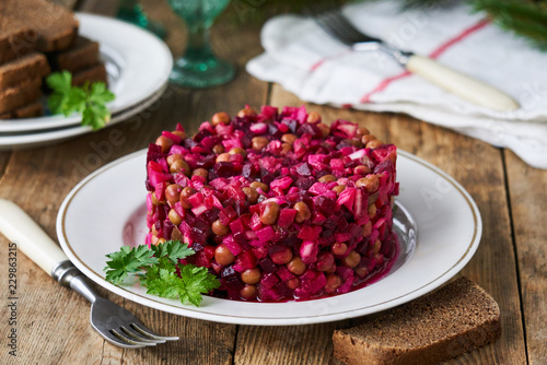 Vegetable salad vinaigrette with beetroot, potatoes, pickles and green peas on a plate