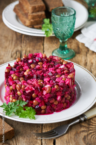 Vegetable salad vinaigrette with beetroot, potatoes, pickles and green peas on a plate