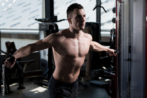 Young Man Exercising Chest In The Gym