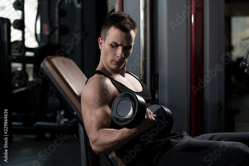 Biceps Exercise With Dumbbells In A Gym