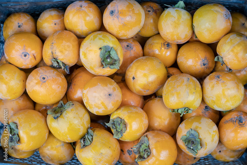 Ripe persimmons tiled on a market stall. Organic persimmon fruits in pile at local farmers market in Tbilisi  Georgia