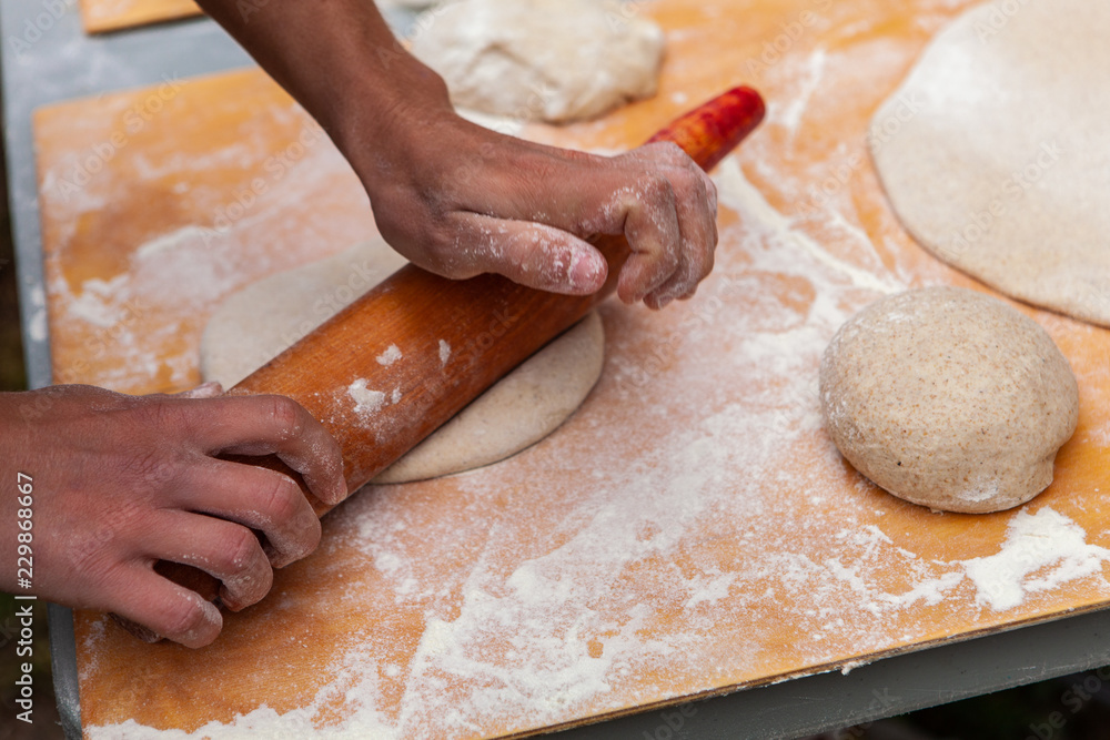 People kneading their pizza doughs as part of an outdoor bread making workshop - Pictures taken during a bread and pizza making workshop with many people from all ages and generations. People kneading their pizza doughs as part of an outdoor bread making workshop - Pictures taken during a bread and pizza making workshop with many people from all ages and generations.