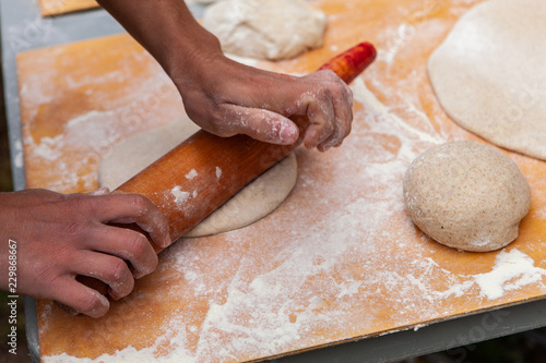 People kneading their pizza doughs as part of an outdoor bread making workshop - Pictures taken during a bread and pizza making workshop with many people from all ages and generations.