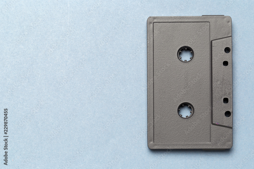 One single retro audio cassette on light grey background, top view One single retro audio cassette on light grey background, top view