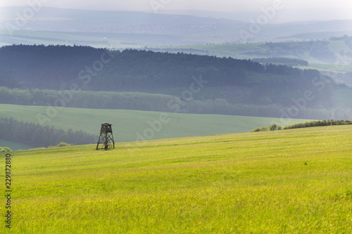 Deer stand, wooden hunters high seat hide on field, summer day, cloudy dramatic sky, Bojkovice, Uherske Hradiste district, Zlin region, White Carpathians, Czech Republic