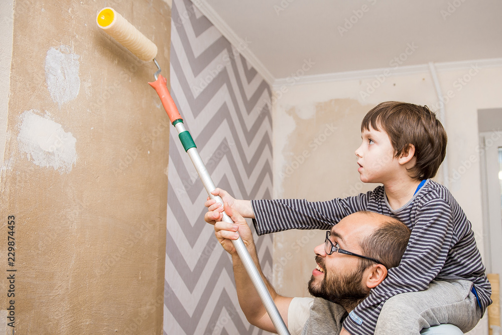 father and child paint walls, glue wallpaper, apply glue. - obrazy, fototapety, plakaty 