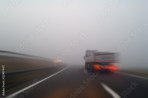 Truck on a highway in motion blur during foggy day