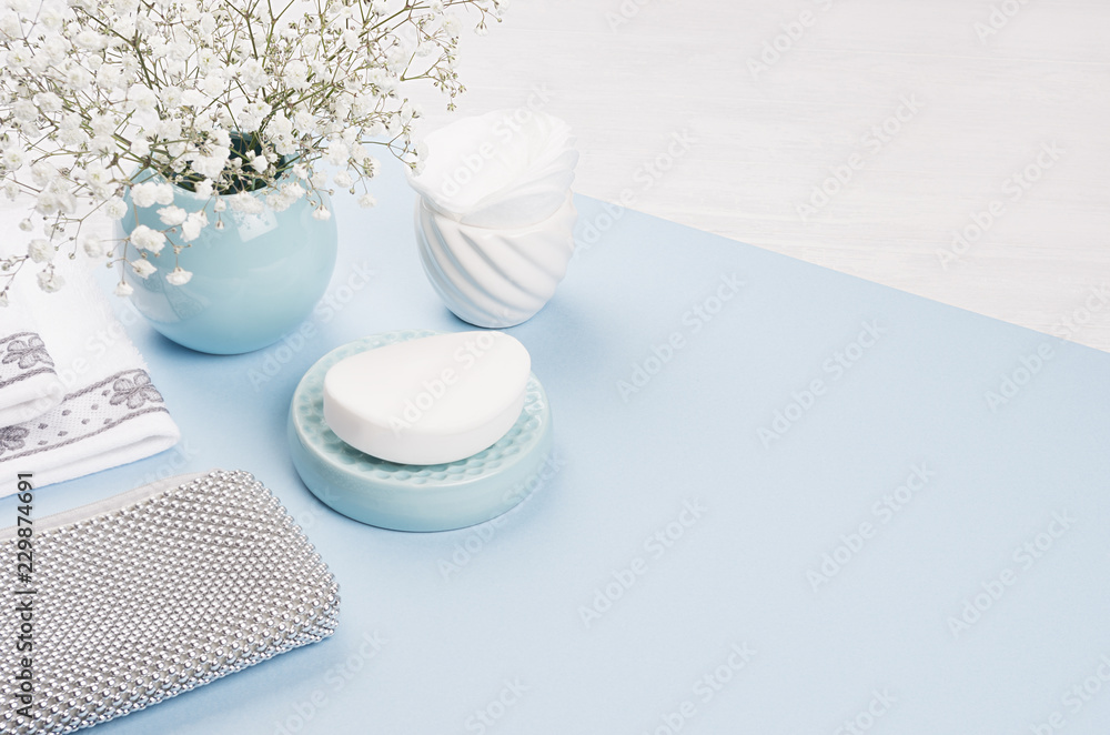 Cosmetics products background - set for body and skin care, blue ceramic bowl, silver accessories, flowers on white wood and color paper, blur, copy space. Cosmetics products background - set for body and skin care, blue ceramic bowl, silver accessories, flowers on white wood and color paper, blur, copy space.
