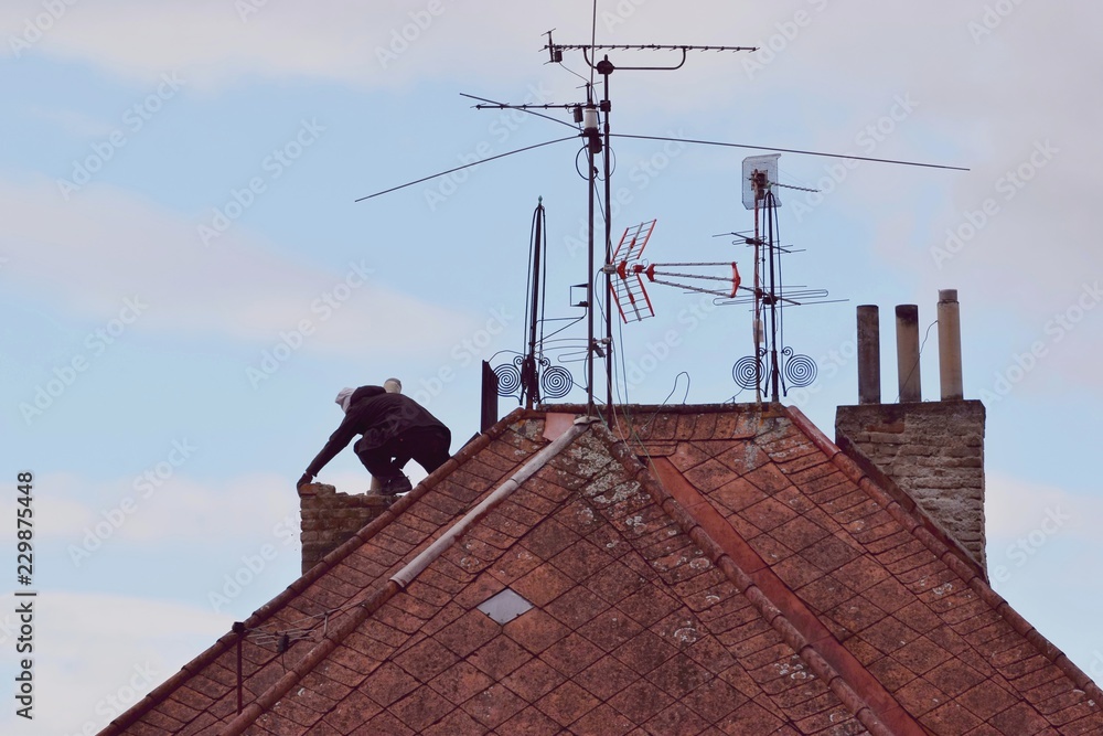 Man renovating an old chimney on the rooftop Man renovating an old chimney on the rooftop