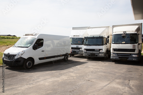 several delivery van and white logistic truck for service transportation in distribution park