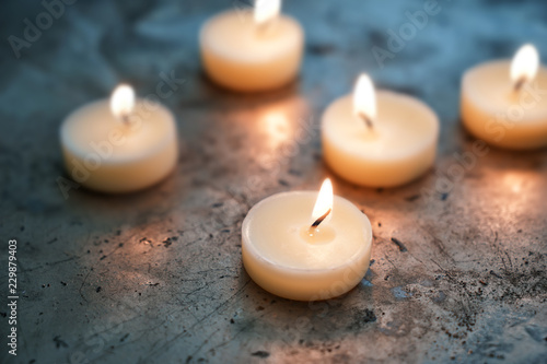 Beautiful burning candles on grey table