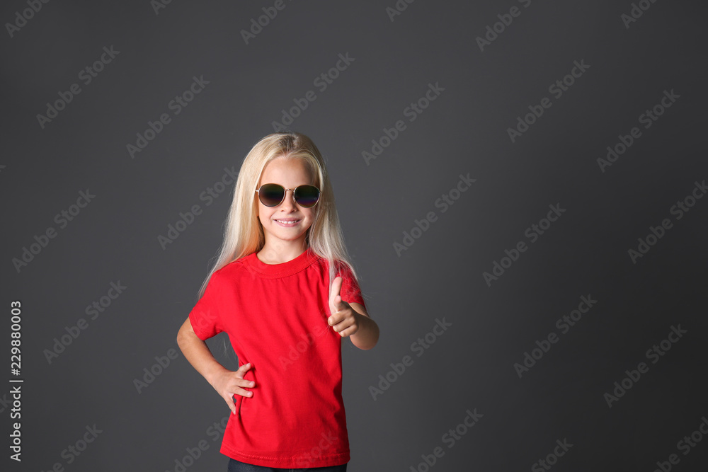Cute little girl in tshirt pointing at viewer on dark background Stock Photo Adobe Stock