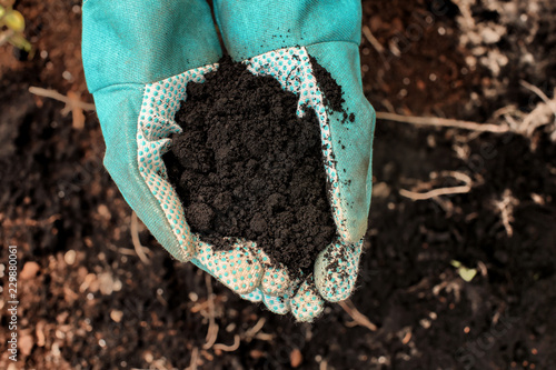 Woman holding black soil ou...