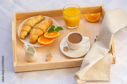 Breakfast in bed with coffee, croissants and juice