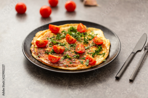 Omelet with tomatoes and herbs. Delicious breakfast