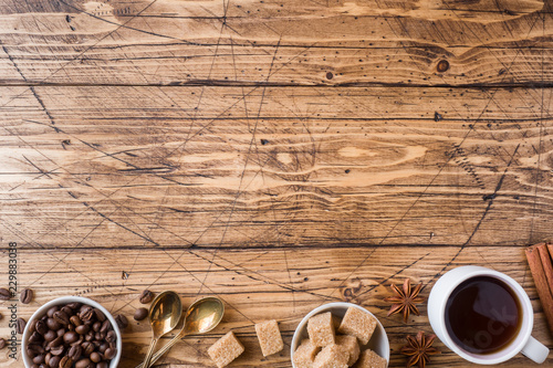 Cup of coffee, brown sugar and cinnamon with anise on a wooden background. Copy space