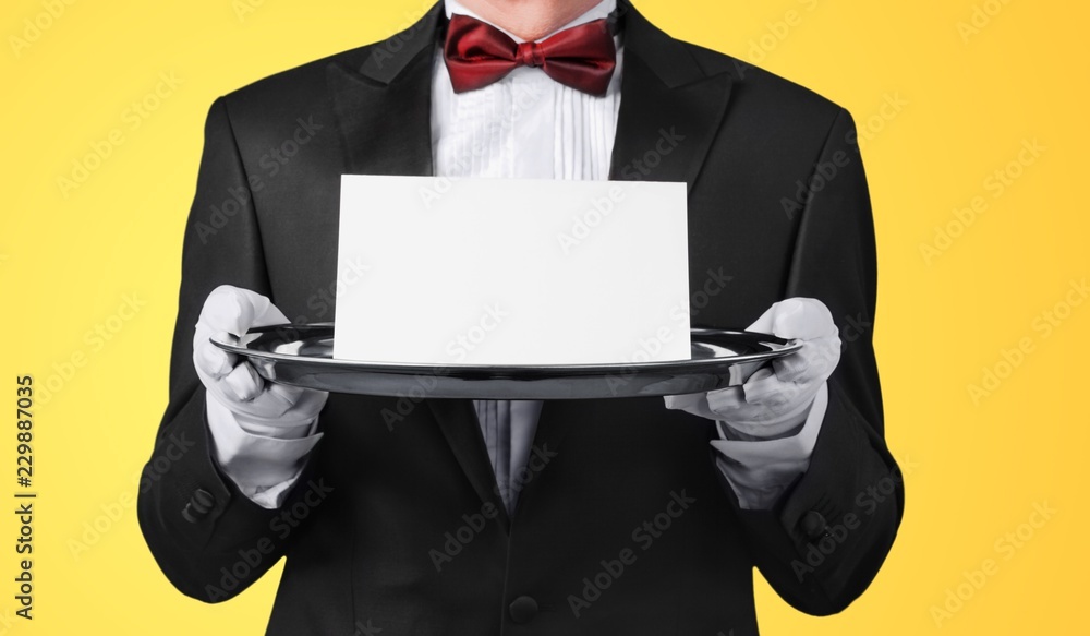 Waiter or butler wearing a tuxedo holding Waiter or butler wearing a tuxedo holding