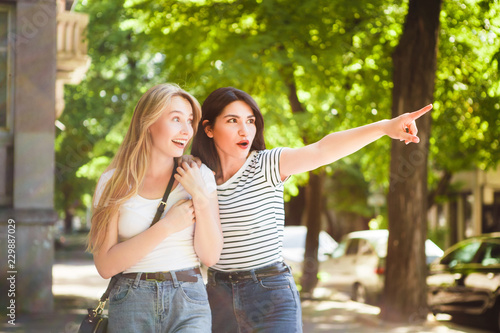 Two young girls hug and laugh.