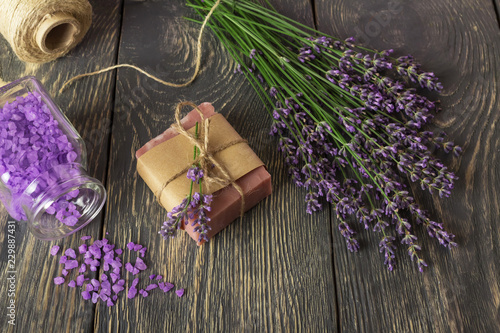 Fototapeta Naklejka Na Ścianę i Meble -  Top view. Handmade soap, fragrant bath salt and lavender on dark boards